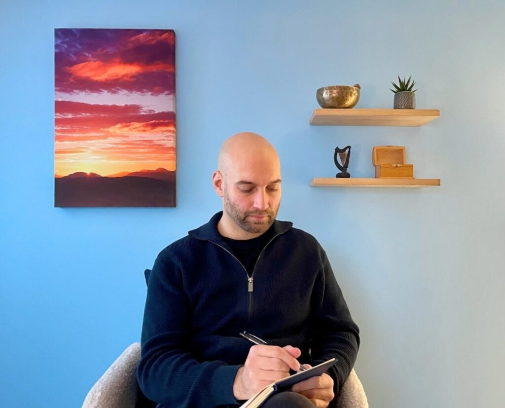 Chris writing notes in a therapy room in Stirling